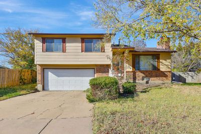 Tri-level home featuring a garage and a front lawn | Image 2