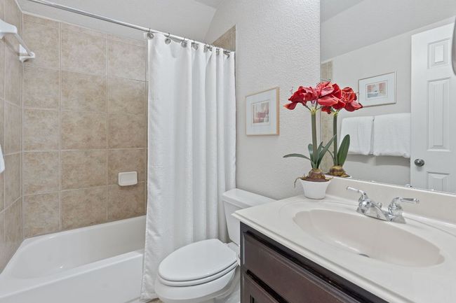 Full bathroom featuring vanity, toilet, shower / bath combo, and a textured wall | Image 18
