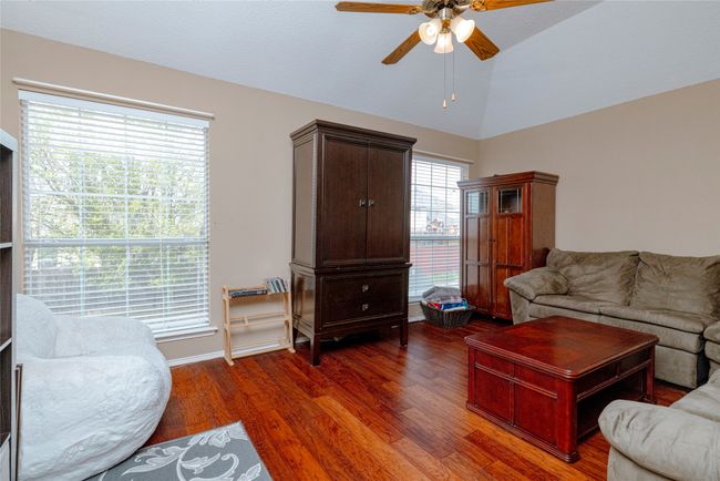Living room with wood finished floors, vaulted ceiling, and a ceiling fan | Image 19