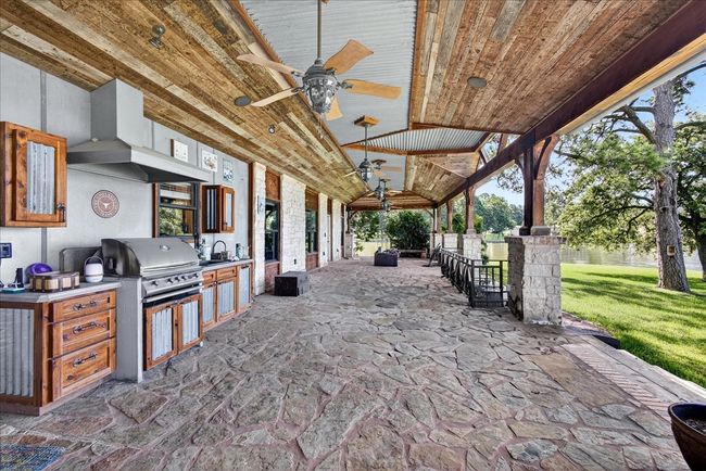 View of patio with area for grilling and a ceiling fan | Image 12