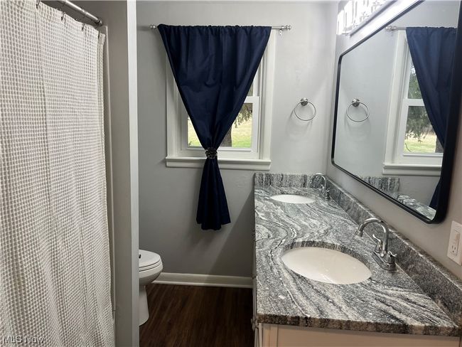 Bathroom featuring hardwood / wood-style flooring, a wealth of natural light, vanity with extensive cabinet space, and toilet | Image 18