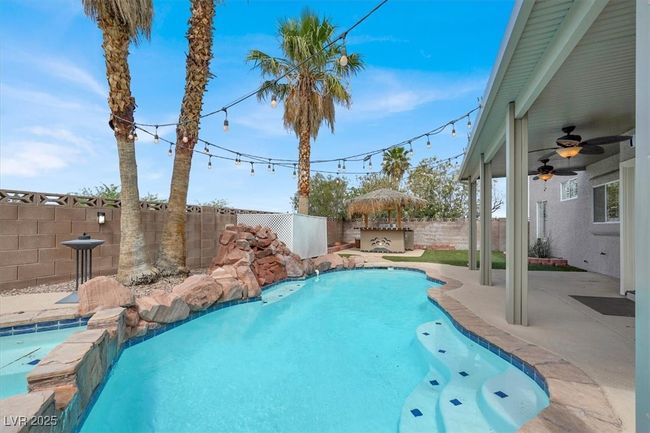 View of pool with ceiling fan, a fenced backyard, and a patio | Image 39