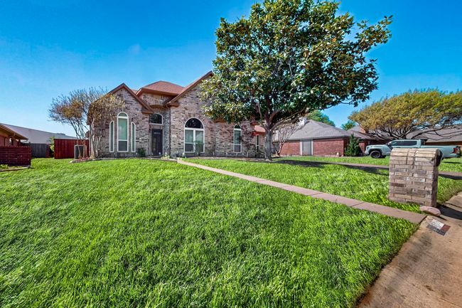 French provincial home with brick siding, fence, and a front lawn | Image 39