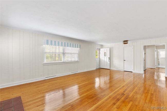 Unfurnished living room featuring a healthy amount of sunlight, light wood-type flooring, and baseboards | Image 6