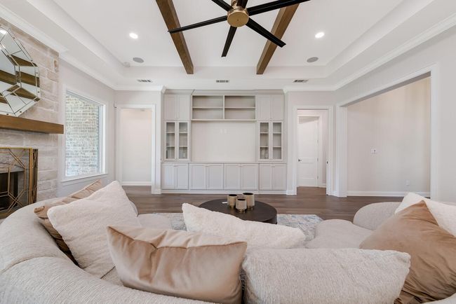 Living area with a fireplace, dark wood-type flooring, ceiling fan, recessed lighting, and beamed ceiling | Image 13