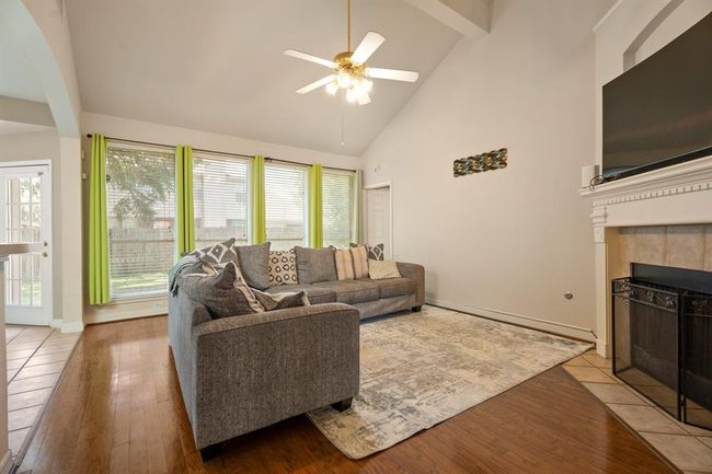 Walking further into your home, you are greeted by a spacious living room, a wall of windows, and a gas fireplace. | Image 4