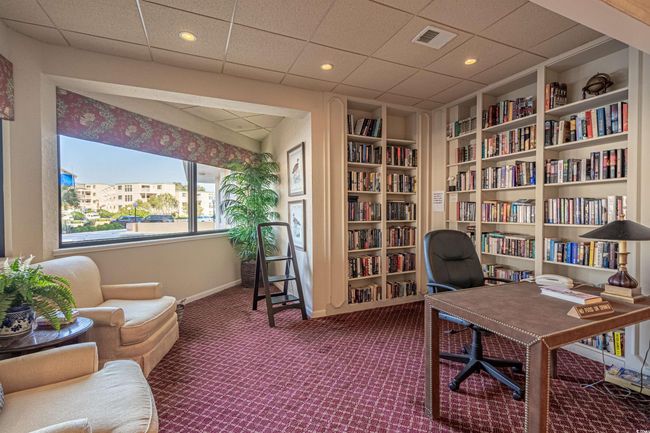 Carpeted living area with plenty of natural light, coffered ceiling, a fireplace, and crown molding | Image 23
