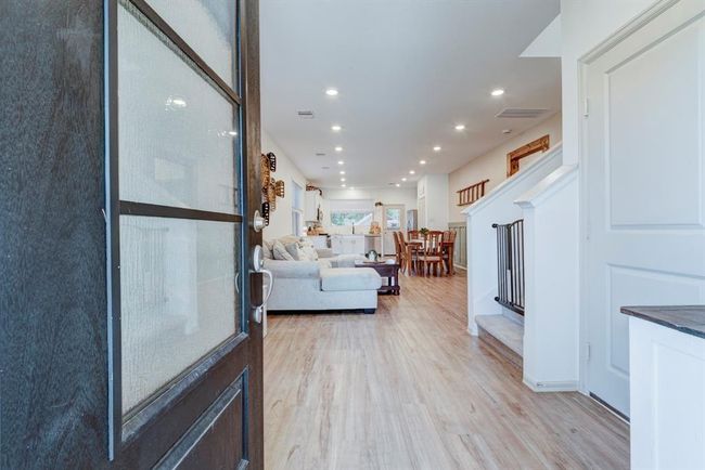 Inside, you'll find an open and airy layout filled with natural light, complemented by fresh paint, stylish finishes, and charming architectural touches throughout. The spacious living area flows seamlessly into the dining space and kitchen, making it ideal for both relaxing nights in and hosting friends and family. | Image 6