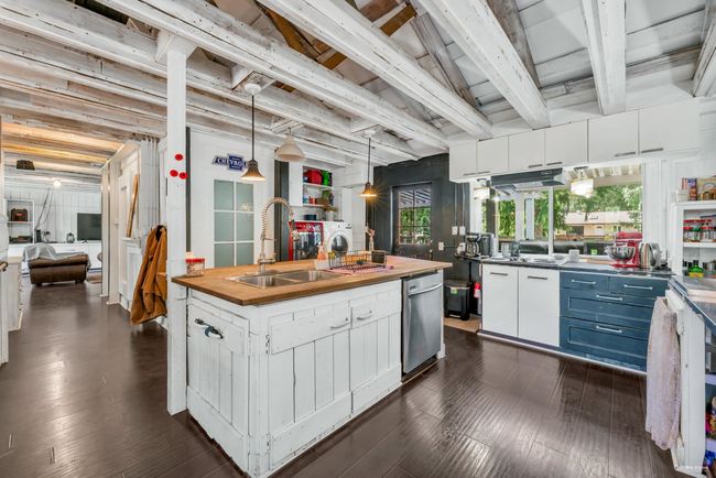 Kitchen featuring white cabinets, a sink, washing machine and clothes dryer, wood counters, and dark wood-style flooring | Image 11