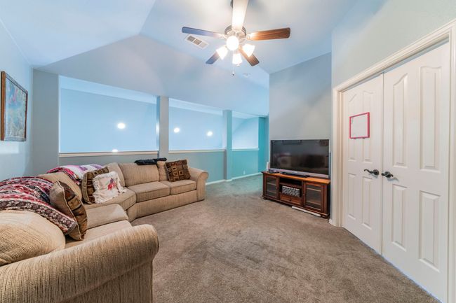 Living area with carpet flooring, a ceiling fan, and vaulted ceiling | Image 25