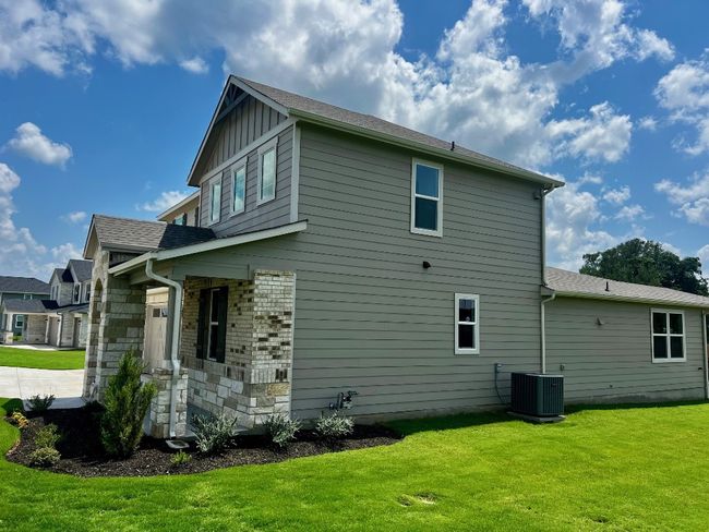 View of home's exterior with a lawn and board and batten siding | Image 4