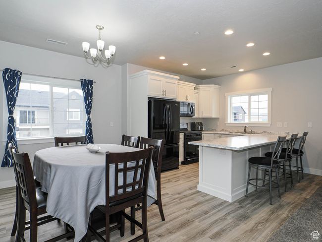 Dining space with recessed lighting, a notable chandelier, light wood finished floors, and visible vents | Image 16