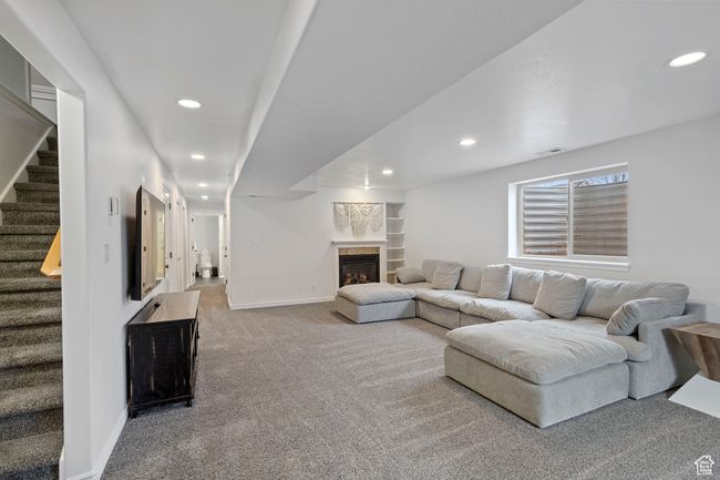 Carpeted living room featuring a tiled fireplace | Image 21