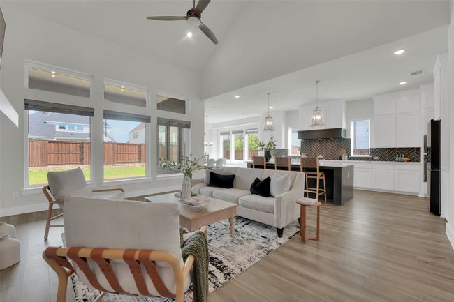 Living room with a ceiling fan, light wood-style flooring, and plenty of natural light | Image 8