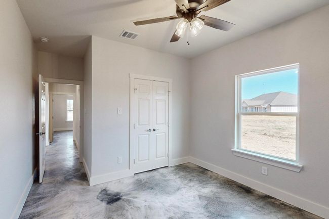 Unfurnished bedroom with a closet, concrete flooring, and baseboards | Image 28