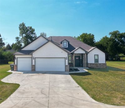 View of front facade with a front yard and a garage | Image 1