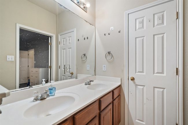 Spacious primary suite on the back of the house for added privacy offers a walk in closet, dual vanities, linen closet plus a window over the shower and tub providing natural light. | Image 24