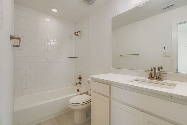Full bath featuring tub / shower combination, vanity, light tile patterned flooring, and recessed lighting | Image 21