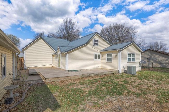 Back of house featuring central air condition unit, metal roof, a wooden deck, and fence | Image 12