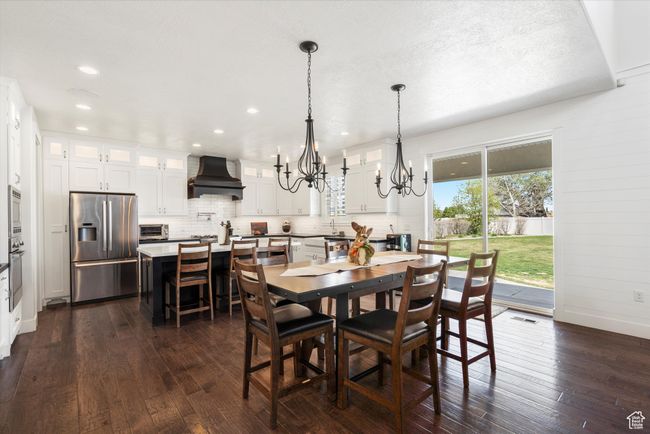 Dining space with an inviting chandelier, baseboards, recessed lighting, and dark wood-style flooring | Image 13