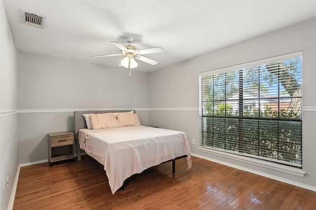 Bedroom with wood finished floors and ceiling fan | Image 12