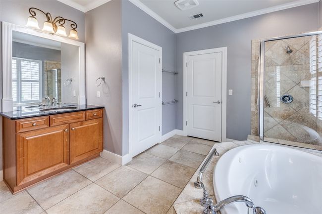 Bathroom featuring a bath, visible vents, ornamental molding, vanity, and a stall shower | Image 15