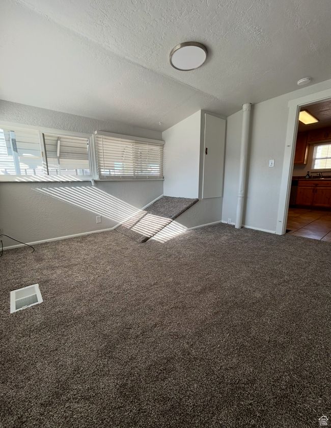 Carpeted spare room featuring a textured ceiling and baseboards | Image 10