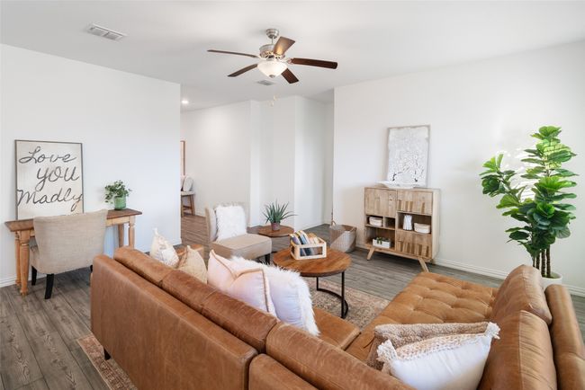 Living area featuring wood finished floors, ceiling fan, and baseboards | Image 6