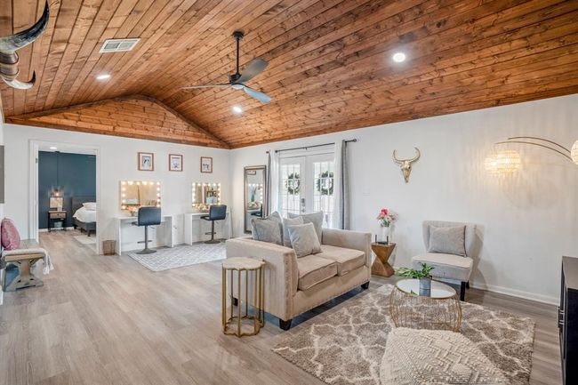 The living area offers plenty of space to relax and gather—highlighted by vaulted wood ceilings and an open, airy feel. | Image 16