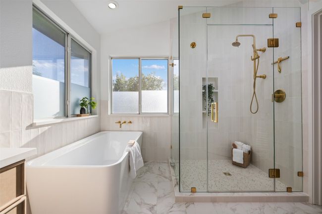 Full bath featuring a freestanding bath, vanity, marble finish floor, a stall shower, and lofted ceiling | Image 27