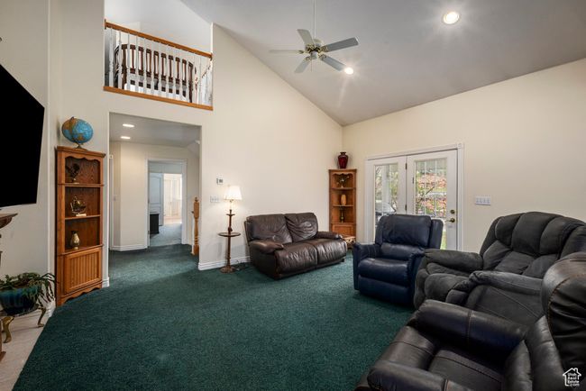Carpeted living room with baseboards, a ceiling fan, recessed lighting, and high vaulted ceiling | Image 15