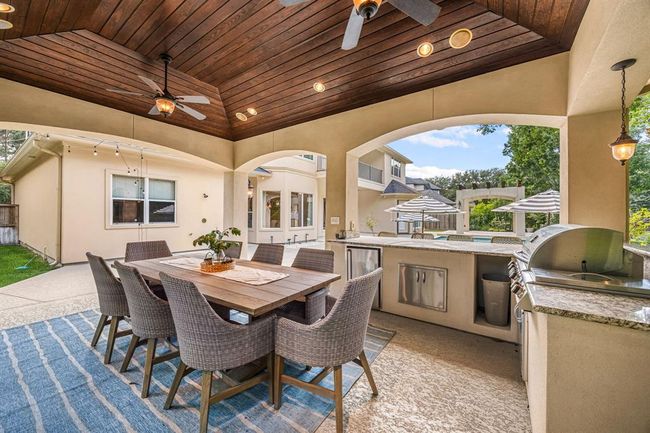 Experience the charm of this spacious patio featuring a stylish wood-accented ceiling and two ceiling fans. Outdoor furniture is available for purchase to complete your perfect outdoor retreat. | Image 47