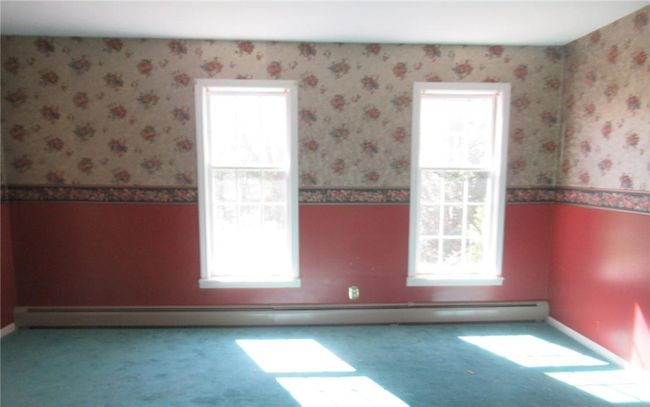 Carpeted empty room featuring a baseboard radiator and a healthy amount of sunlight | Image 4