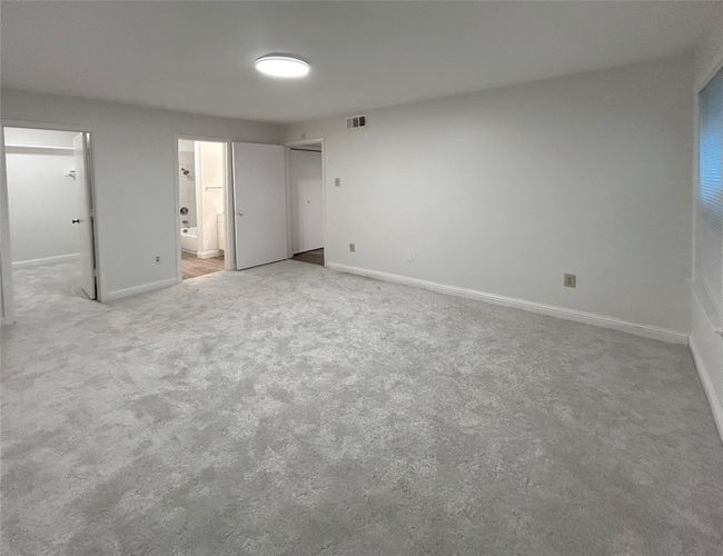 Unfurnished primary bedroom with ensuite bathroom and light carpet | Image 17