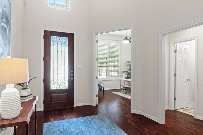 Foyer entrance with wood-type flooring, a towering ceiling, and ceiling fan | Image 17