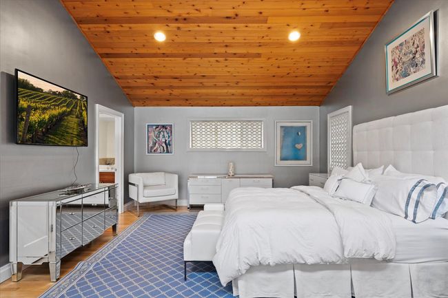 Bedroom with lofted ceiling, wooden ceiling, wood finished floors, recessed lighting, and ensuite bath | Image 10