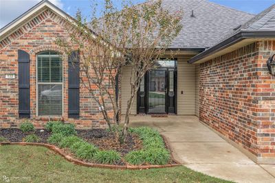 Front exterior view featuring a nice front entrance with custom glass storm door and easy care landscaping. | Image 2