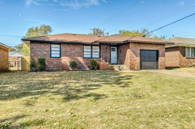 View of front of property featuring a front lawn and a garage | Image 1