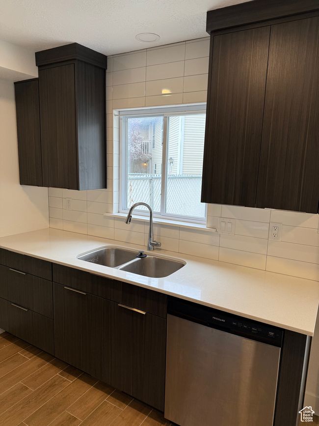 Kitchen with a sink, dark brown cabinets, stainless steel dishwasher, and decorative backsplash | Image 4