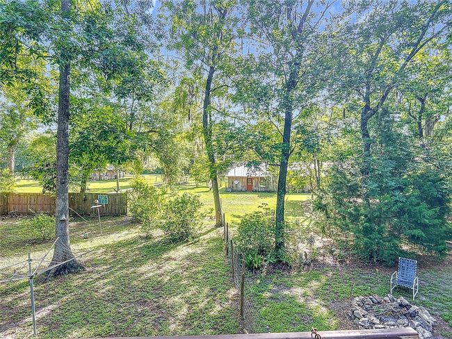 Firepit area and fenced in back yard, which encompasses approximately 1/4 acre. There are a variety of fruit bearing trees in this area. | Image 36