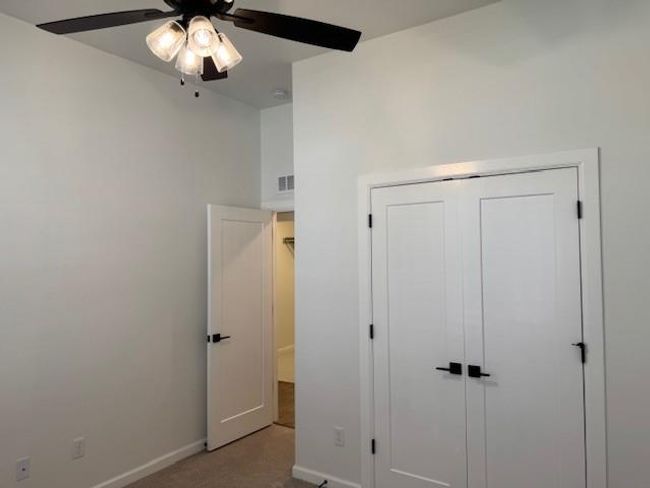 Unfurnished bedroom with a closet, carpet, baseboards, visible vents, and a ceiling fan | Image 29
