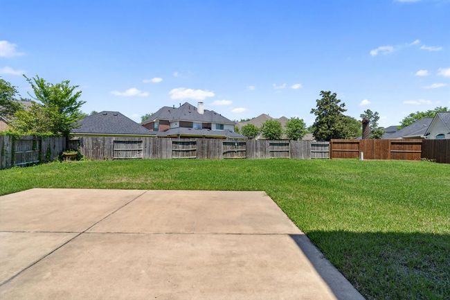 Step outside to the large backyard with a covered patio, perfect for outdoor dining or relaxing. | Image 31