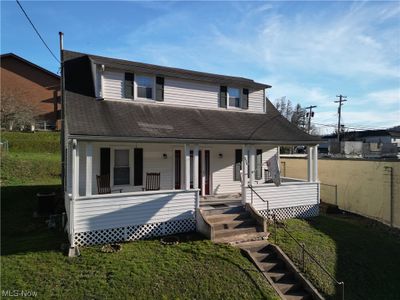 View of front of home with central AC, covered porch, and a front lawn | Image 2