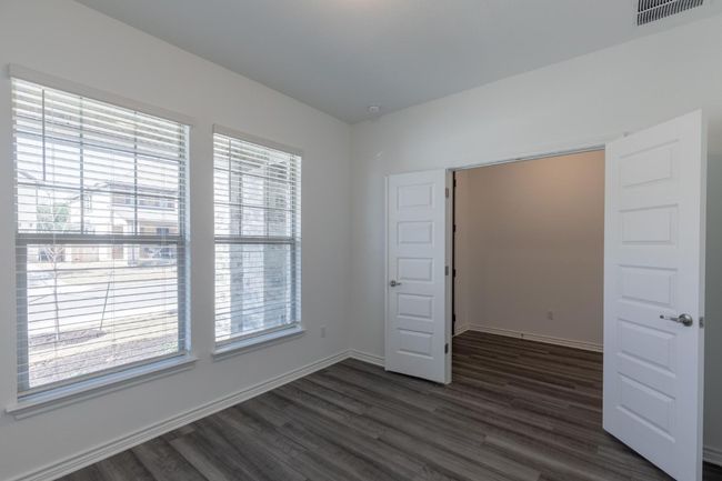 Unfurnished room featuring baseboards, a healthy amount of sunlight, visible vents, and dark wood-style floors | Image 7