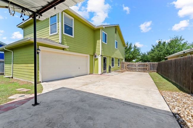 View of side of property with a garage, concrete driveway, and a gate | Image 37