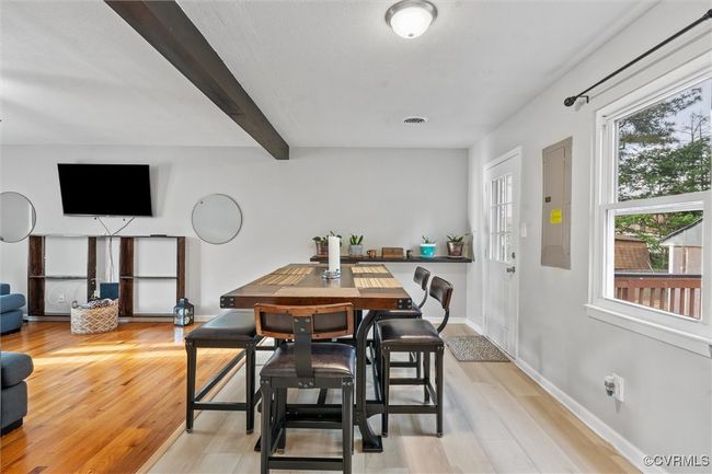 Dining room with beam ceiling, electric panel, light wood finished floors, and plenty of natural light | Image 12