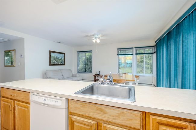 Dining space featuring a baseboard heating unit, light wood-style flooring, a ceiling fan, and baseboards | Image 20