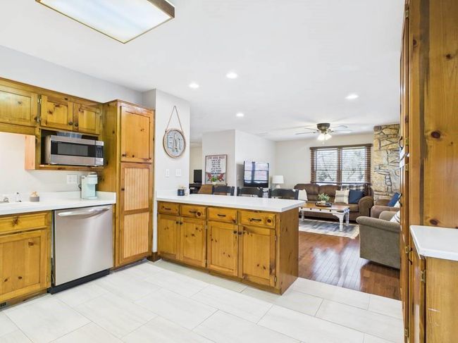 Kitchen featuring a peninsula, open floor plan, light countertops, wood cabinets, and appliances with stainless steel finishes | Image 38