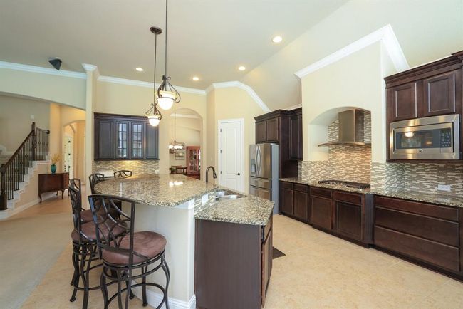 Ample space between cooktop and island. 5 burner gas cooktop. | Image 17