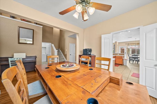 Dining room with a ceiling fan, stairs, and light tile patterned flooring | Image 7